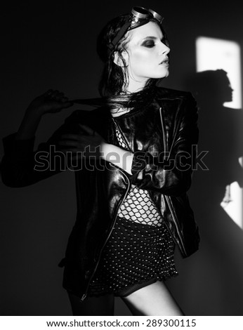 sexy woman model dressed punk, wet look, posing in the studio