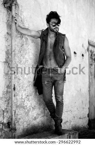 attractive man model dressed punk, hipster posing dramatic in grunge location