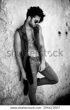 attractive man model dressed punk, hipster posing dramatic in grunge location