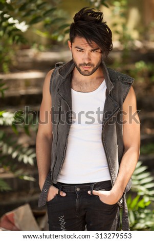 handsome man model dressed punk, hipster posing dramatic in grunge location