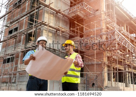 Construction engineers discussion with architects at construction site or building site of highrise building