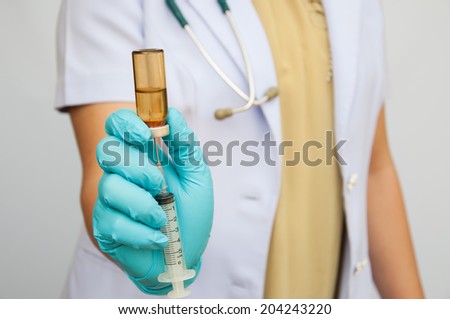 hands preparing and checking a needle syringe