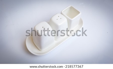 Ceramic salt and pepper shaker on white background composition