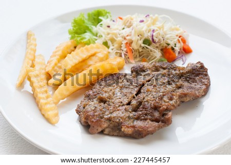 steak served with crisp golden French fries and fresh green herb salad