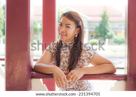 Chinese woman dress traditional cheongsam ,close up portrait with old wood door