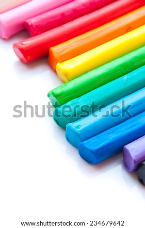 Rainbow colors plasticine play dough modeling clay isolated over white.