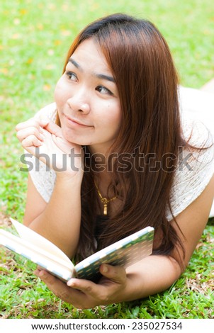 beautiful asian woman reading a book in the garden