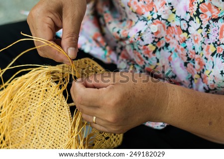 old craftsman hands who works the cane to create a wicker basket