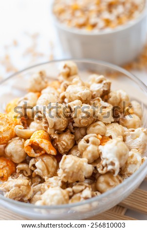 A bowl of popcorn on a wooden table, caramel popcorn
