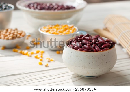 collection set of beans, legumes, peas, lentils on ceramic spoons on white wooden background