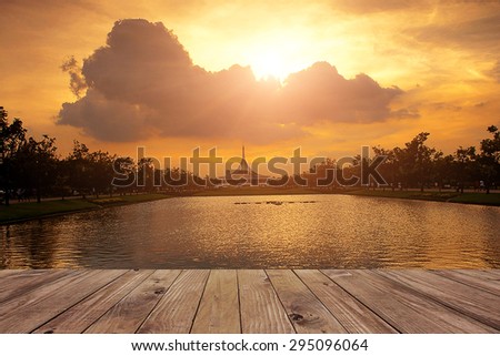 Wooden platform beside lake with sunset