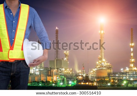 engineering man and safety helmet standing against oil refinery plant in industrial estate