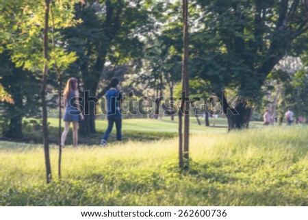 Blurred Asian couple strolling in the park in summer on a weekend