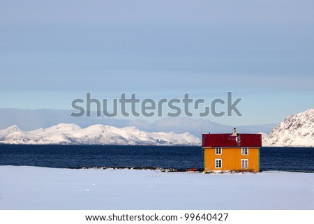 Colorful cabin in snowy landscape on seashore