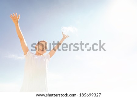 Happy Boy outside, both arms up in the air. Blue sky. Photo in retro vintage look