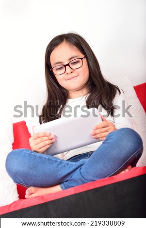Little cute schoolgirl learning with a Tablet PC at home