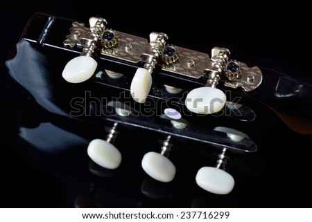 Head of an acoustic guitar with tuning pegs and tuning machine heads