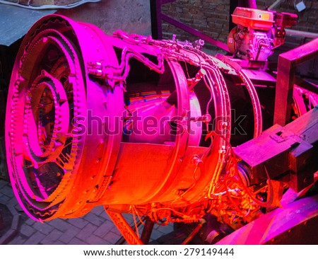 Modern electric motor fragment, pink red toned photo. Car engine. Fragment of modern automobile motor