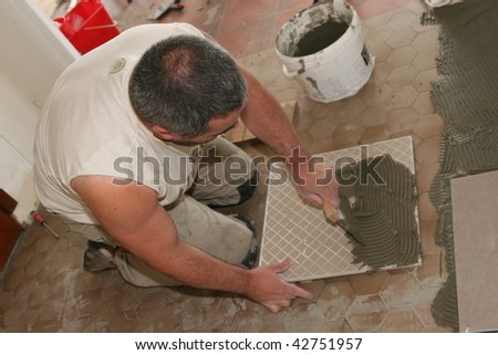 man installs ceramic tiles on the floor