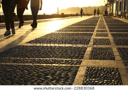 People walking along the promenade at sunset. Altafulla, Catalonia, Spain.