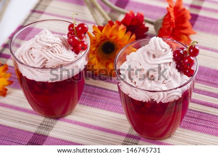 Red dessert in a glass - red current jelly with a whipped cream on the top