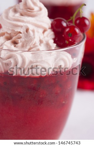 Red dessert in a glass - red current jelly with a whipped cream on the top