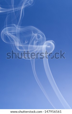 An abstract photo close up - solid blue background with a smokes swirls