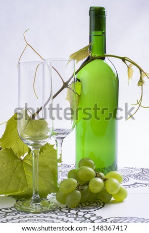 White wine bottle presented with wine glass on a bright background