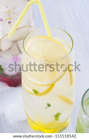Fresh fruit and water drink with a sliced fruits - pears, lemon, mint herb and ice.