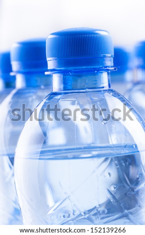Couple of sparkling water blue bottles composition on a bright solid background.