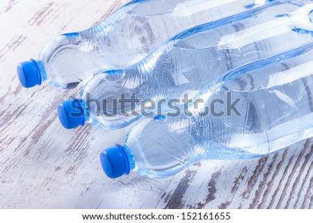 Couple of sparkling water blue bottles composition on a bright solid background.