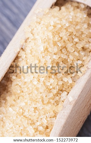 Close up photo of  sugarcane in a spatula on a dark solid wooden background.