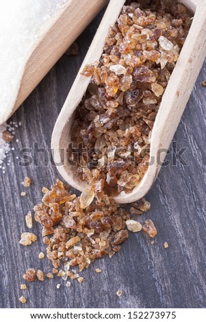 Close up photo of caramelized sugar in a spatula on a dark solid wooden background.