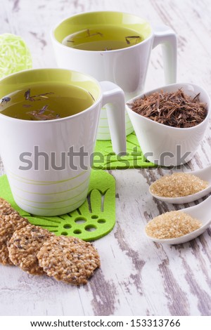 Close up photo of the herbal tea - cup of tea with a biscuits on the bright background.