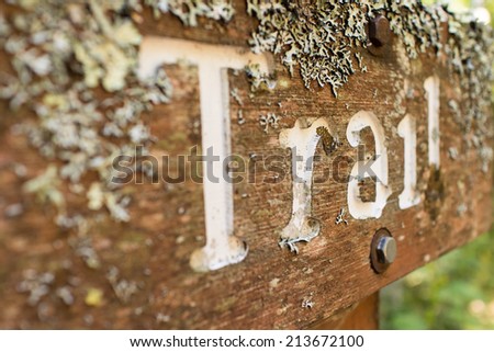 A lichen-covered sign that says \
