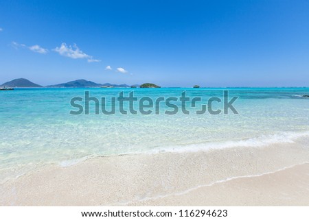 Clear blue water lapping on white sand beach of tropical island, Okinawa, Japan