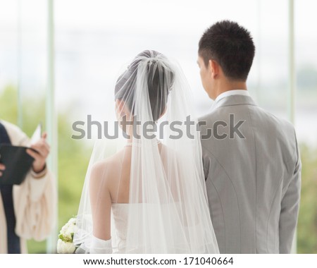 Couple in white wedding ceremony Couple in white wedding ceremony