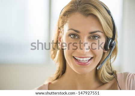 Front view portrait of beautiful young female customer service representative wearing headset