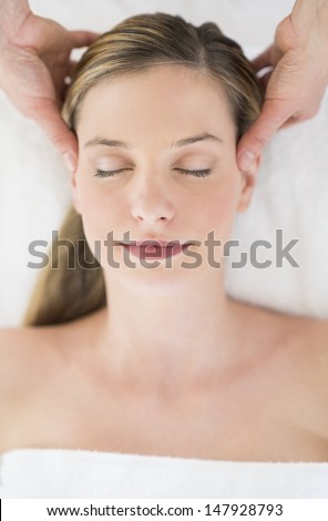 Directly above shot of relaxed young woman receiving head massage at health spa