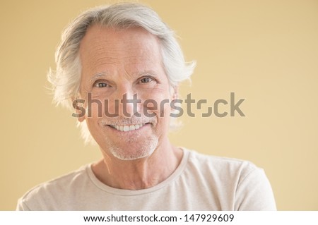 Portrait of happy senior man isolated over beige background