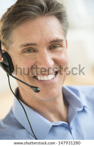 Portrait of happy male customer service representative wearing headset