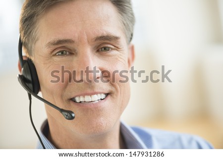 Closeup portrait of confident male customer service representative wearing headset