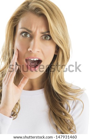 Close-up portrait of surprised young Caucasian woman shouting against white background