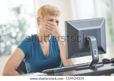 Serious businesswoman with hand over mouth