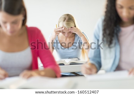 Frustrated teenage student sitting at desk