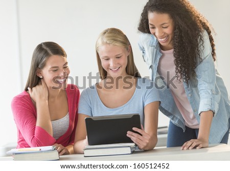 Teenagers using digital tablet in classroom