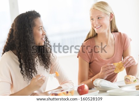 Teenage girls having snacks in university canteen