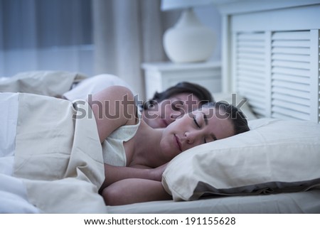 Young couple resting together in bed at home