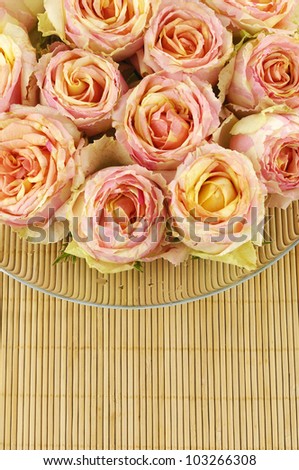 bowl of roses on stick straw mat