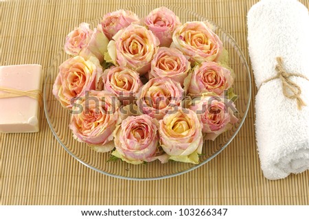bowl of rose with towel and soap on stick straw mat